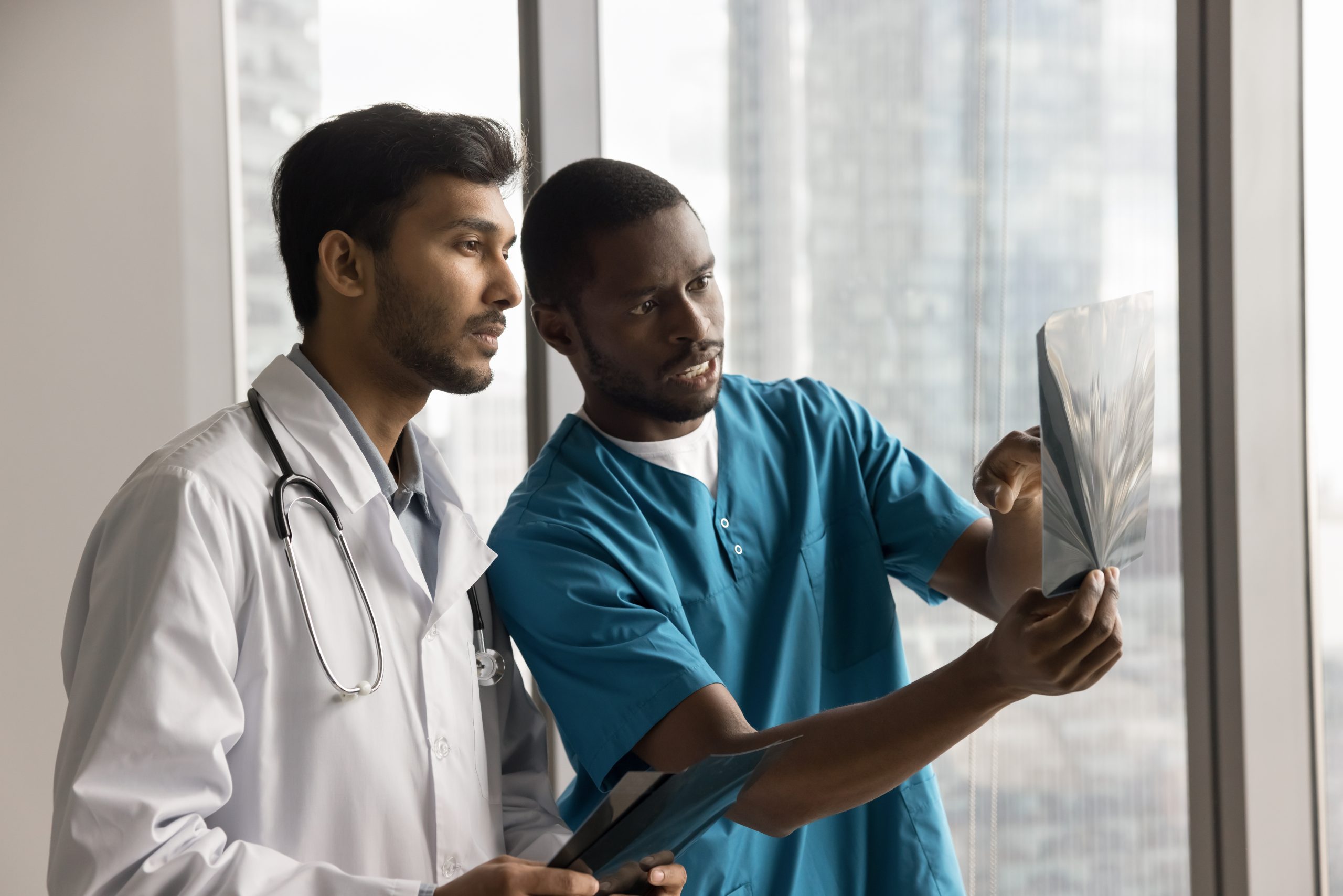 Two,Multiethnic,Doctors,Radiologists,Or,Surgeons,Dressed,In,White,Coat